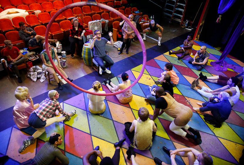 Director Derek Whitener (seated, framed in ring) assembles his cast for last-minute...