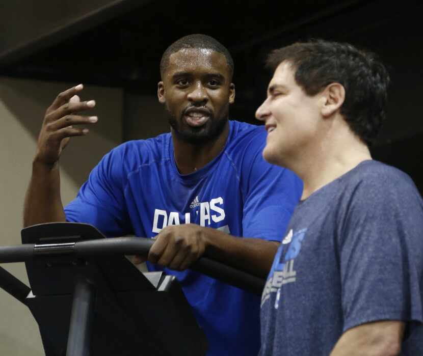 Dallas Maverick Wesley Matthews talks with owner Mark Cuban at the end of practice at...