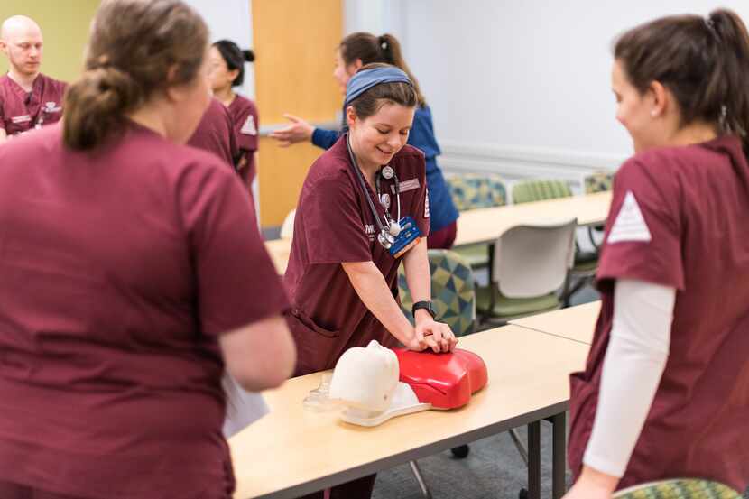 A Texas Woman's University nursing students gives chest compressions to a CPR manikin.