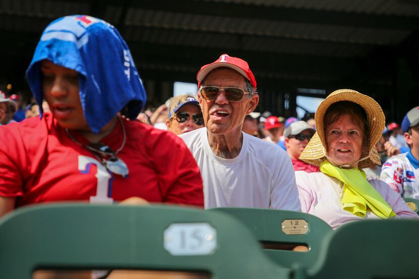 Texas Rangers fans try to beat the heat as they watch their team face the Seattle Mariners...