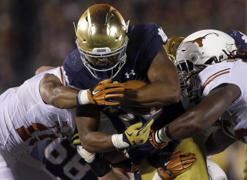 Notre Dame running back C.J. Prosise, center, runs with the ball against Texas cornerback...