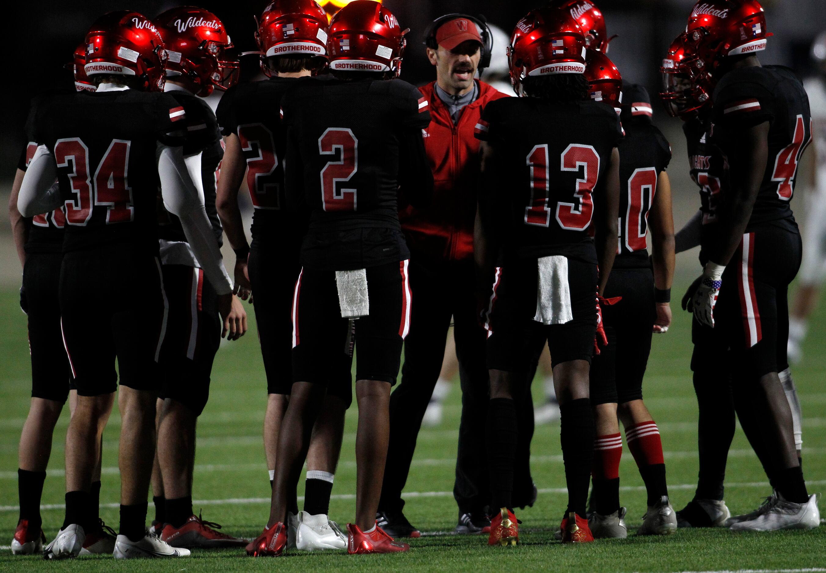 Dallas Woodrow Wilson head coach Tony Benedetto, center, gives instructions to his players...