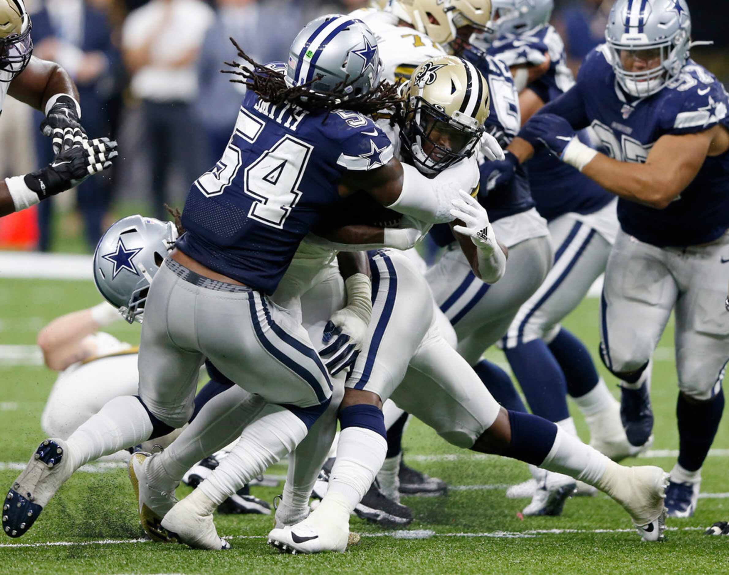 Dallas Cowboys defensive end Demarcus Lawrence (90) gets his leg stuck in front of New...