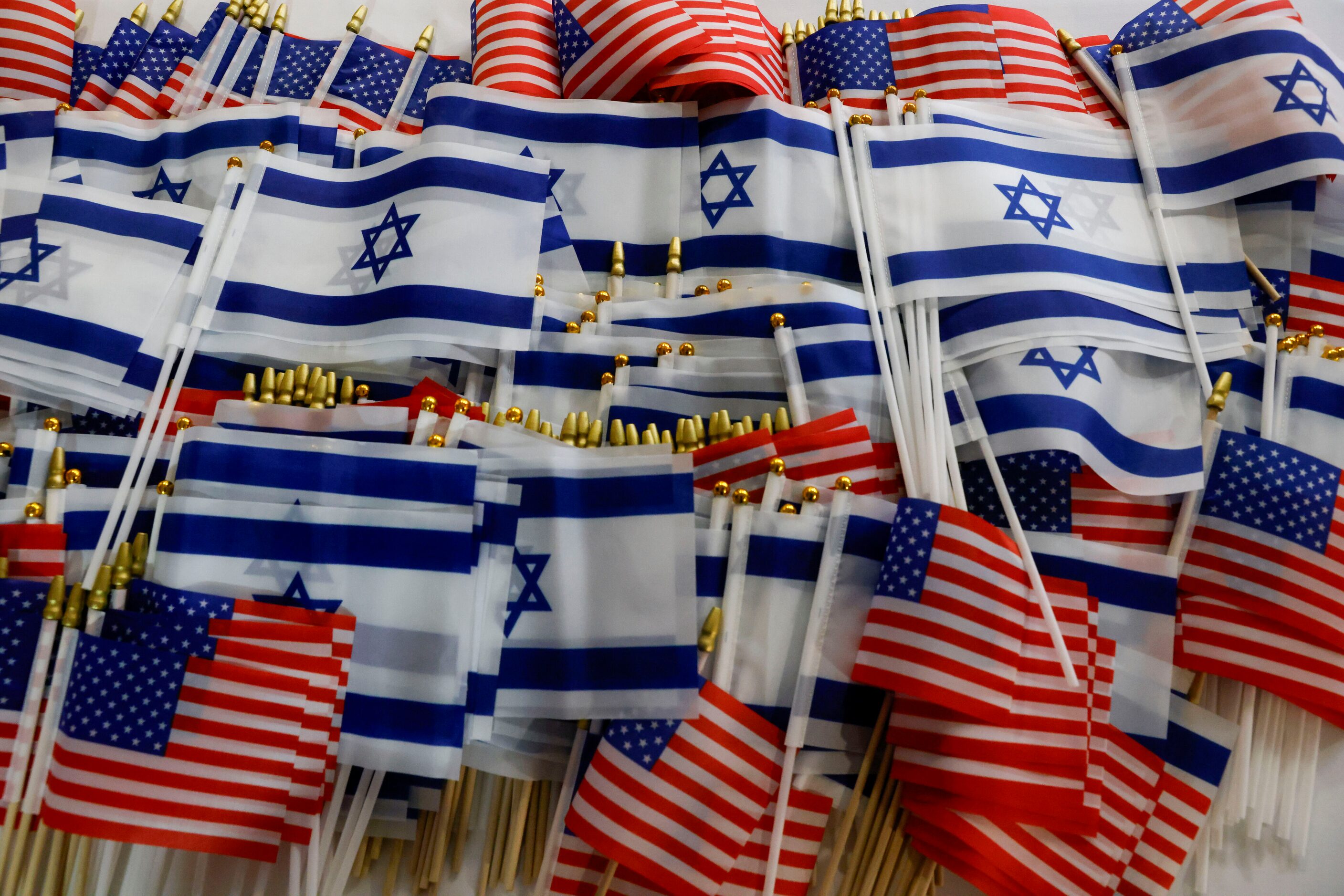 Israeli and American flags sit on a table for people to take before a community event...