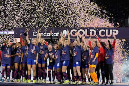 United States' Lindsey Horan holds the trophy alongside teammates after the United States...
