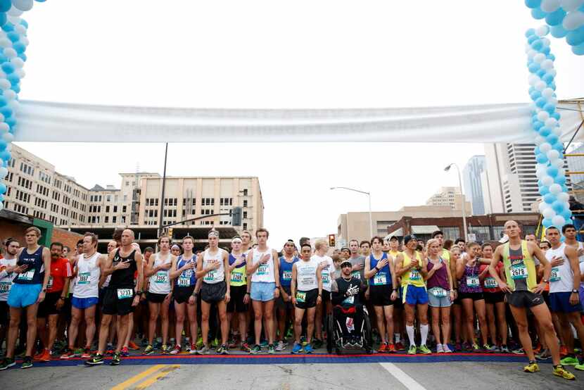 Runners sing the National Anthem before the Dallas YMCA Turkey Trot in downtown Dallas on...