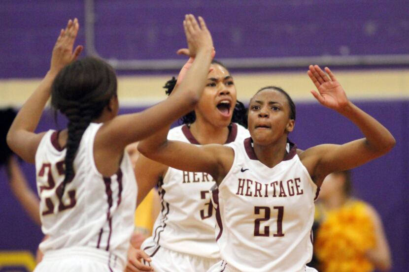 Frisco Heritage Lady Coyotes Montoria Tripp (21) right, celebrates a two-point shot with...