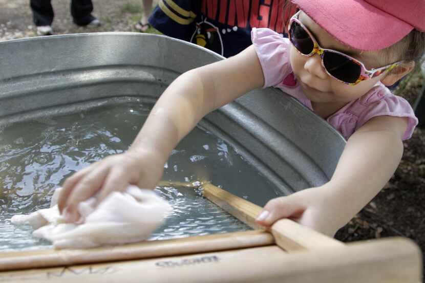 Rebecca Fuentes gets to experience the feeling of washing a cloth on a washboard at hands on...