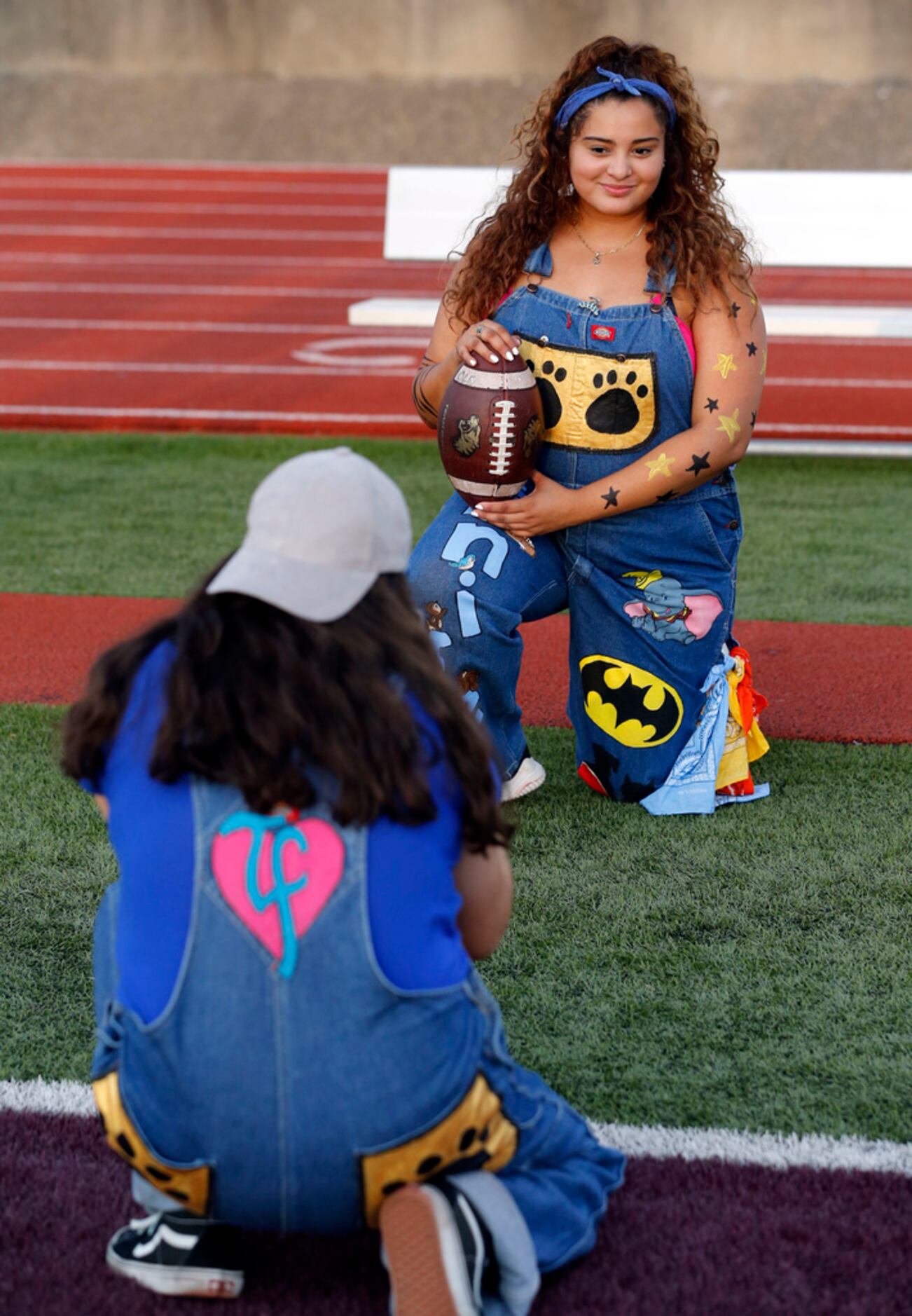 Irving spirit squad member Jennifer Ventera, right, poses with a football as another member...