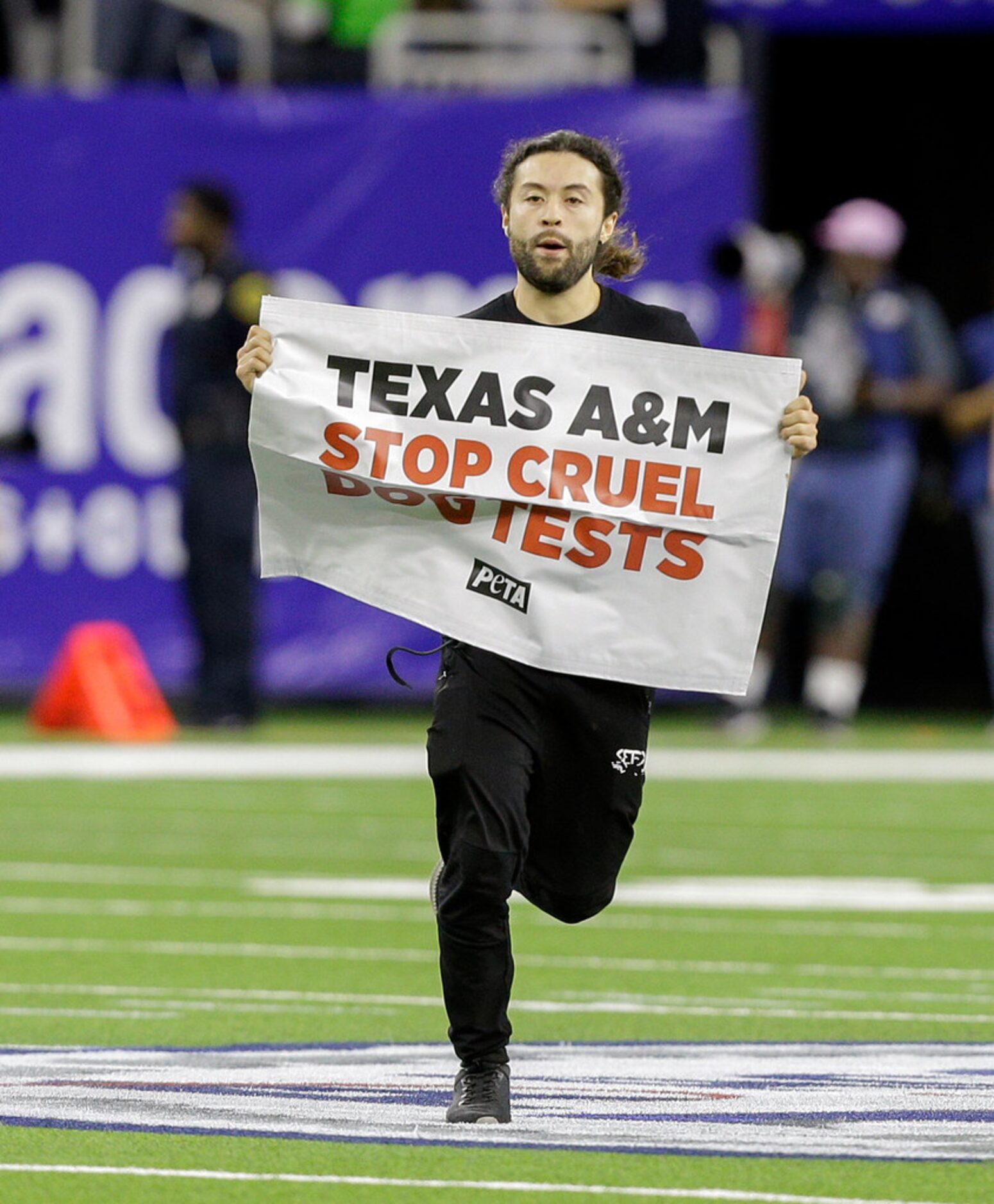 HOUSTON, TEXAS - DECEMBER 27: Protester  runs on the field during the second quarter during...