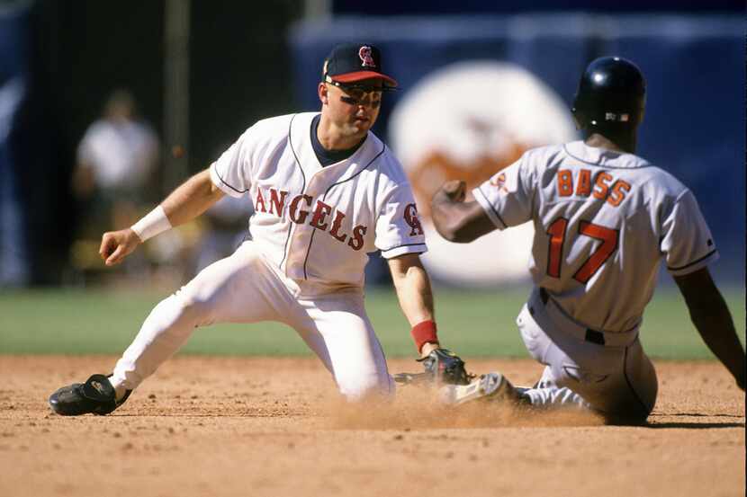 In this file photo, Spike Owen of the California Angels tags out Kevin Bass #17 of the...