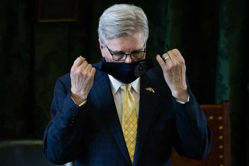 Texas Lt. Gov. Dan Patrick takes his mask off before he presides over the State Senate on...