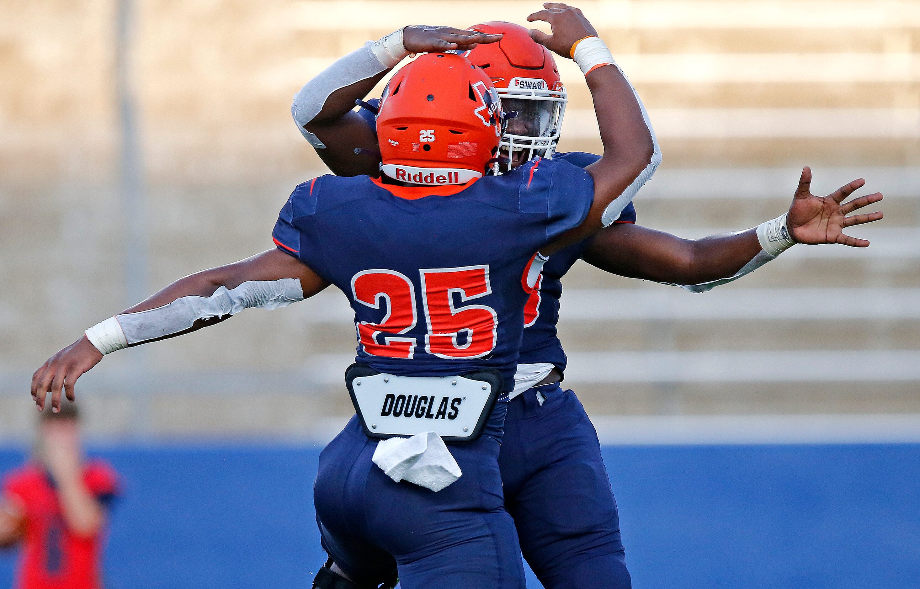 McKinney North High School running back Jadan Smith (25) congratulates McKinney North High...