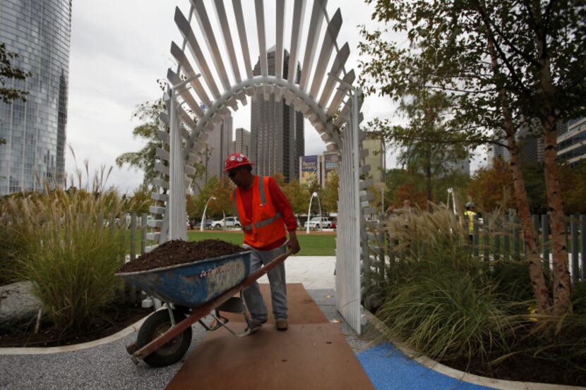 A construction worker hauled in mulch for the children's play area of Klyde Warren Park on...