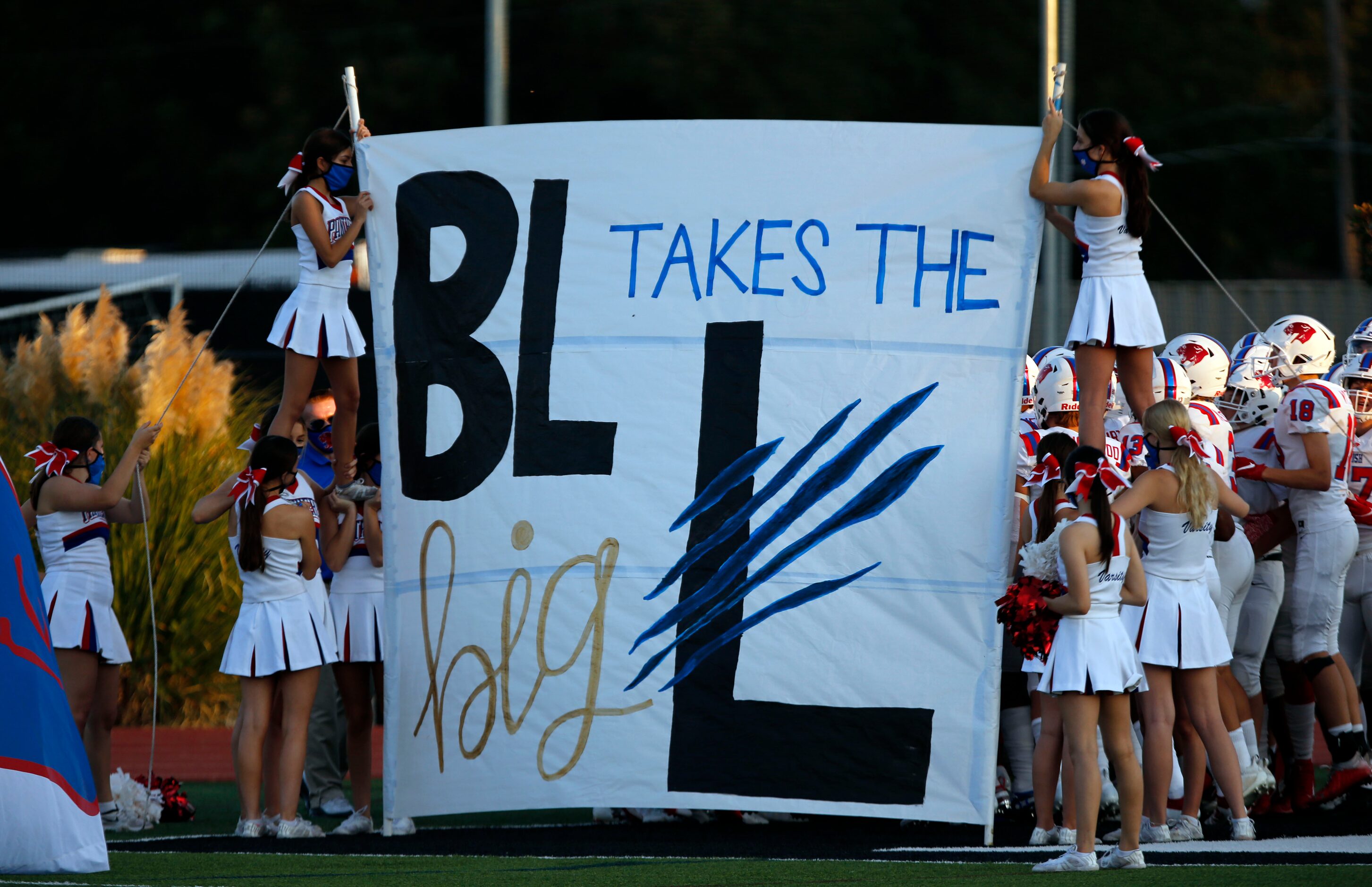 The Parish Episcopal team lines up to run through a banner before the first half of high...