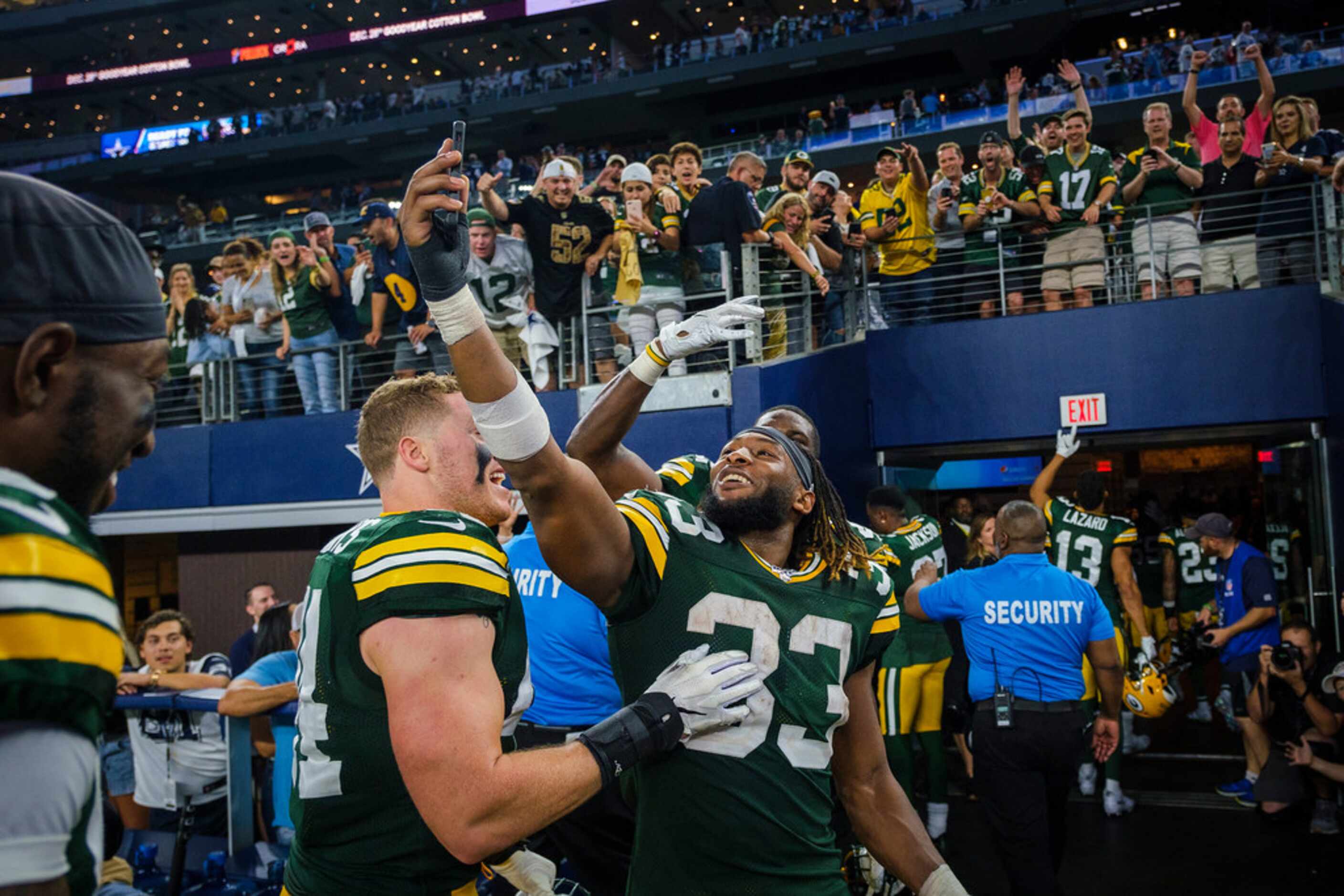 Green Bay Packers running back Aaron Jones (33) celebrates with teammates as they leave the...