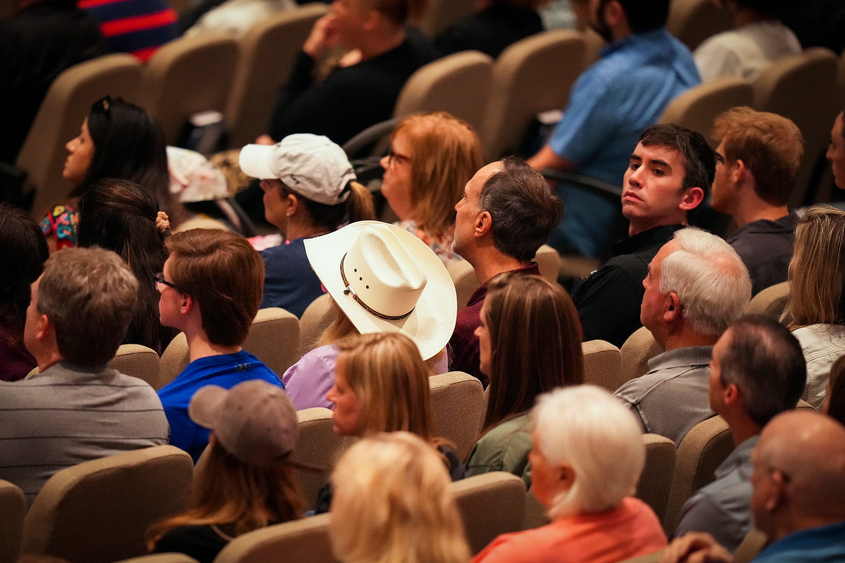 People listen to a speaker during a vigil at Cottonwood Creek Church a day after a mass...