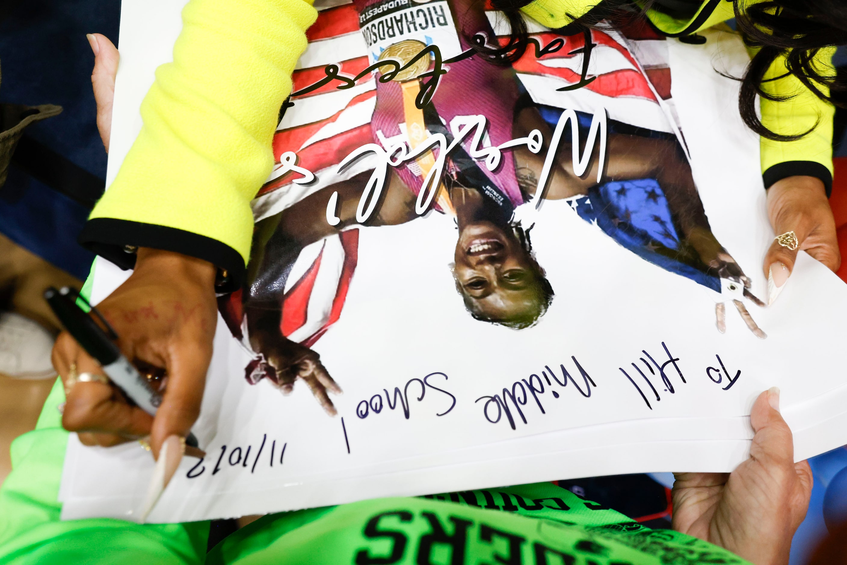 100 meters world champion Sha'Carri Richardson, gives an autograph to a poster for Hill...