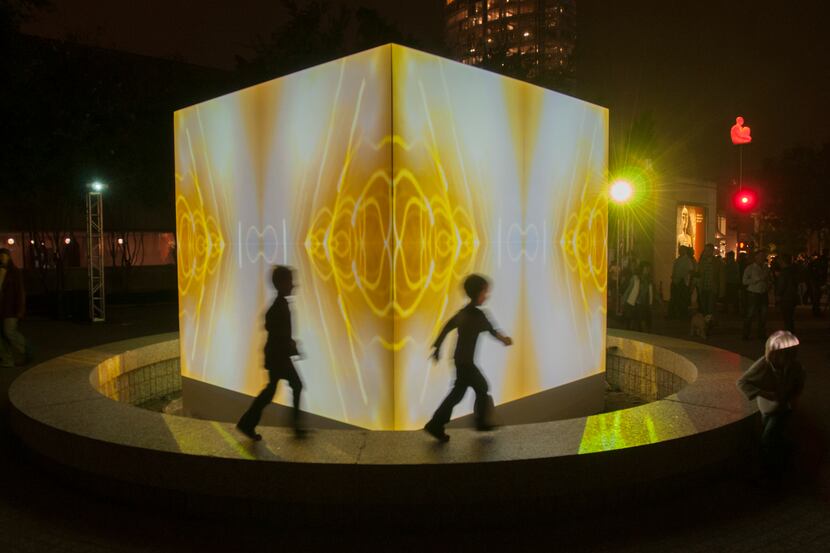 Children play in front of a lighted  art installation at Aurora 2013.