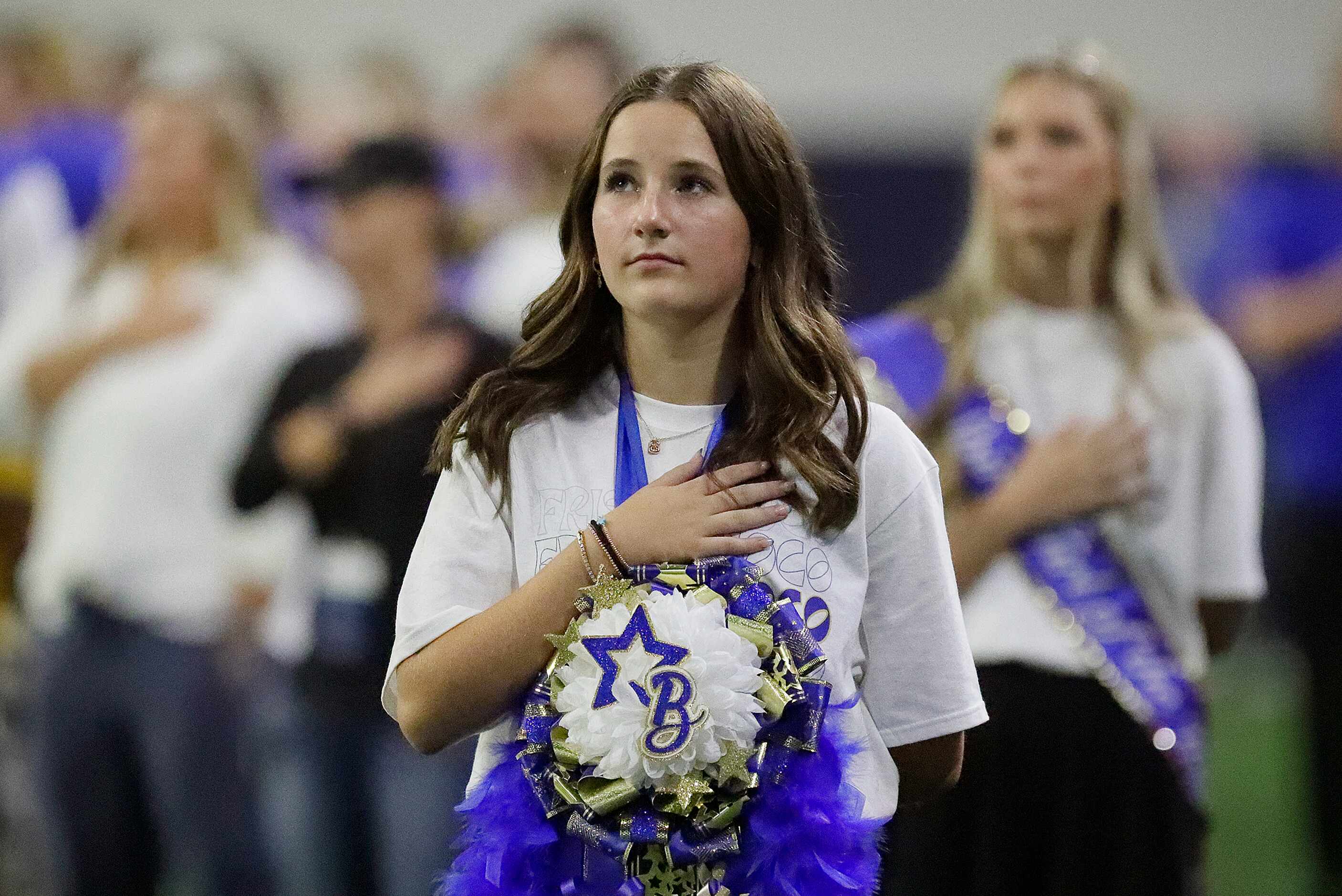 Drill team manager for Frisco High School, Belle Blissett, 14, stands at attention for the...