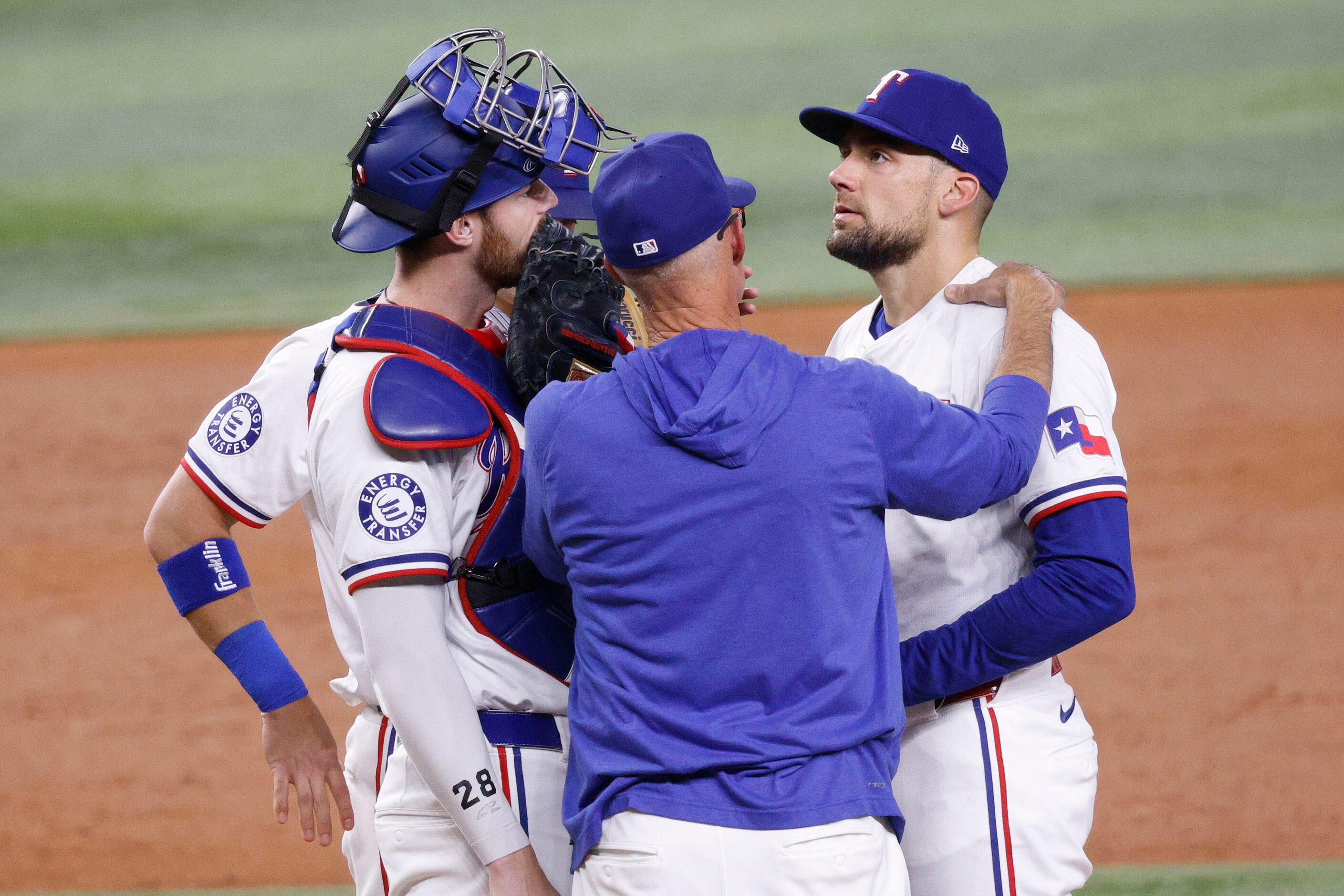 Texas Rangers pitching coach 
Mike Maddux, center, speaks to Texas Rangers pitcher Nathan...