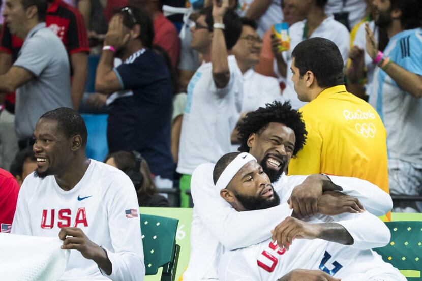 DeAndre Jordan of United States hugs teammate Demarcus Cousins on the bench during the final...