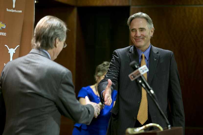 Steve Patterson, right, reaches out to shake hands with University President Bill Powers,...
