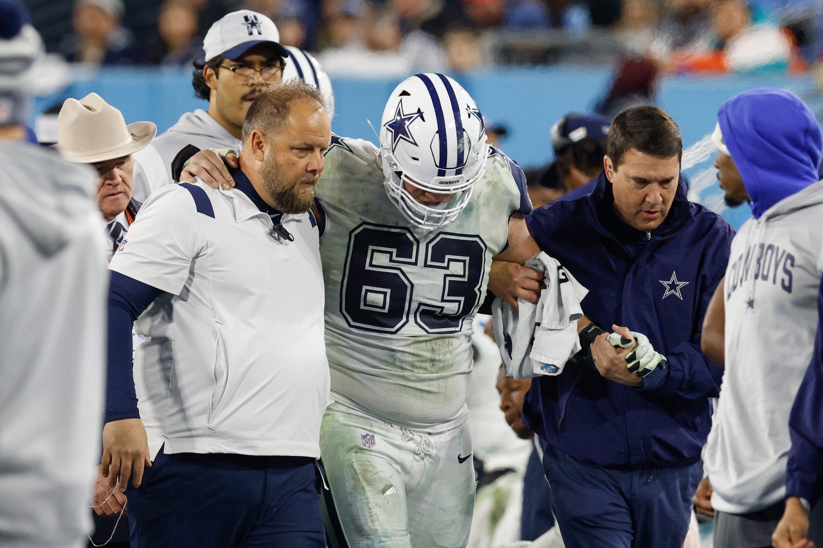 Dallas Cowboys center Tyler Biadasz (63) is helped to the locker room after hurting his...