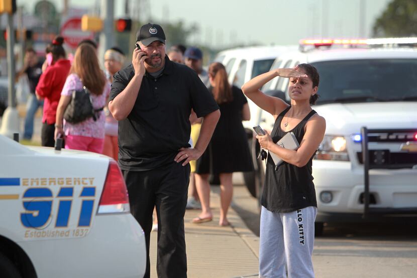 Parents gather Wednesday morning outside Spring High School after a stabbing during a fight...