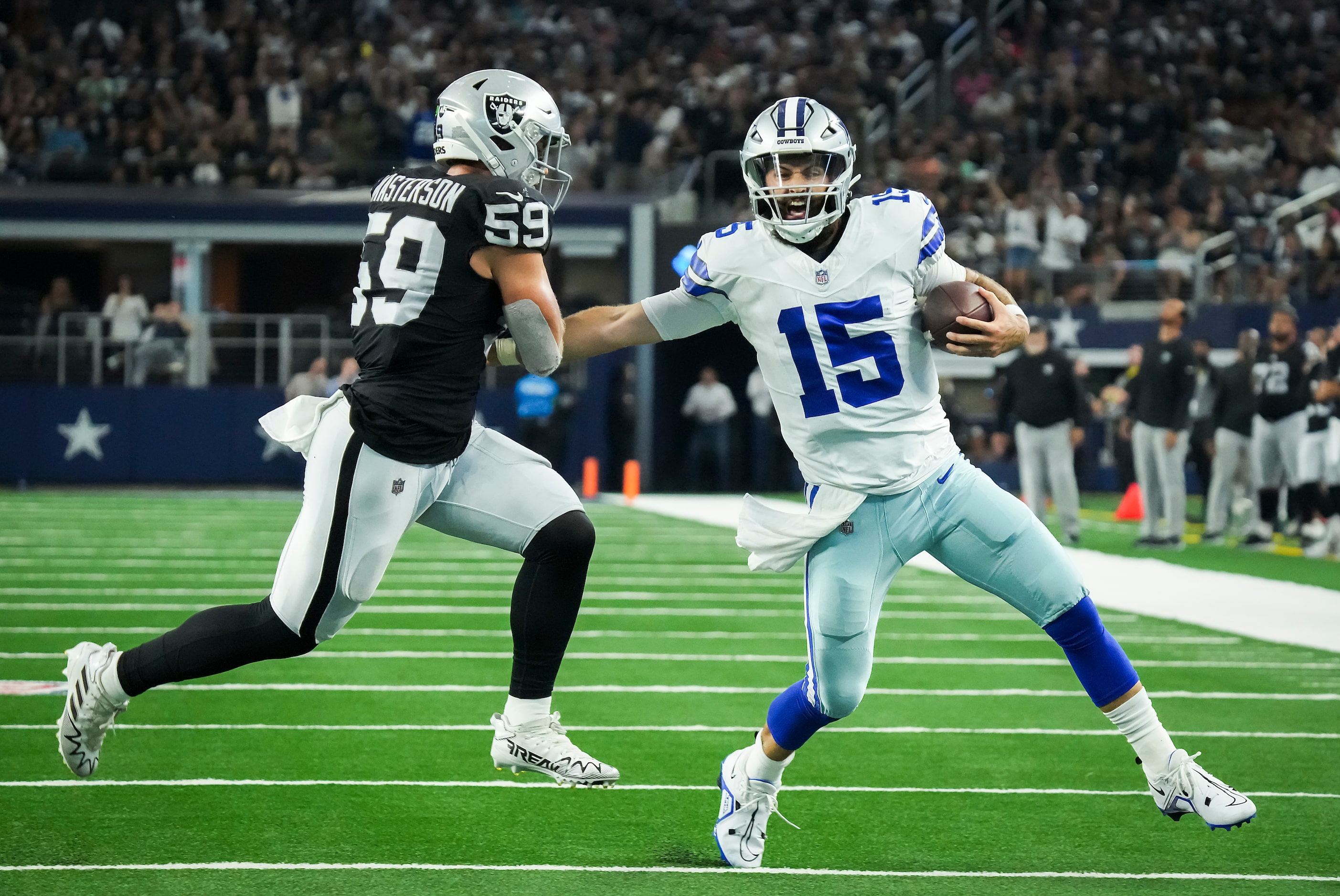 Dallas Cowboys quarterback Will Grier (15) scrambles for a first down past Las Vegas Raiders...