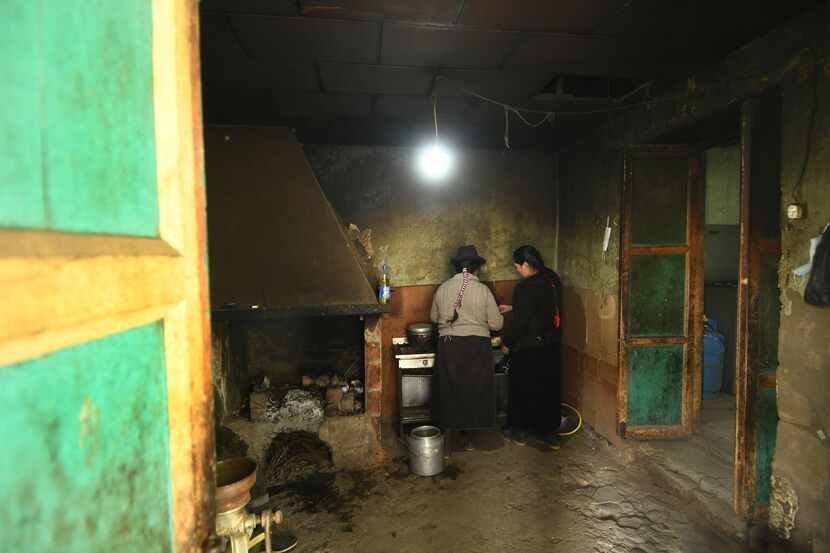 María, de 51 años y su hija Estefanía de 21 años, preparan comida en la cocina de su casa en...