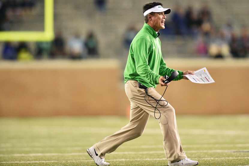 North Texas interim head coach Mike Canales takes his headset off while yelling in to his...