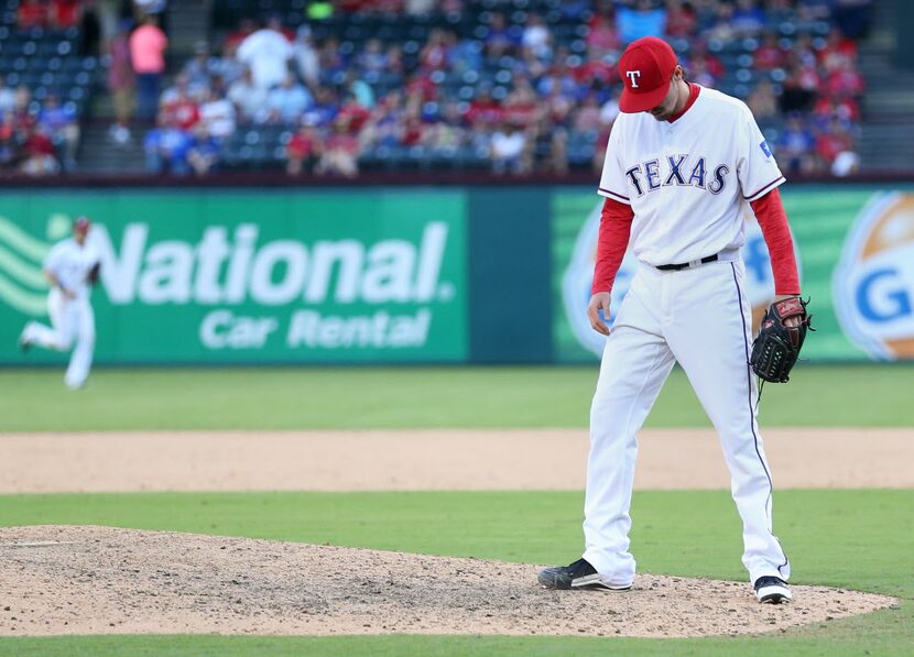 Texas Rangers relief pitcher Tanner Scheppers (52) reacts after giving up a double to Tampa...