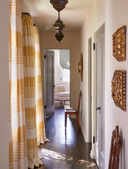 Residential hallway with yellow plaid curtains, gold artwork and Moroccan lanterns