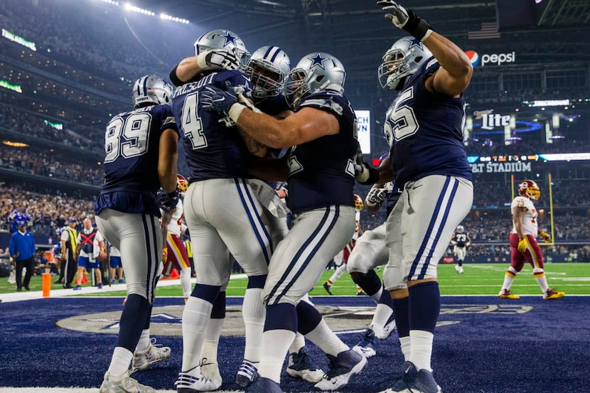 The Dallas Cowboys celebrate after quarterback Dak Prescott (4) runs the ball in for a...