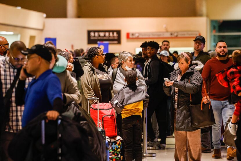 Travelers wait in line to be served by Southwest customer service staff after most flights...