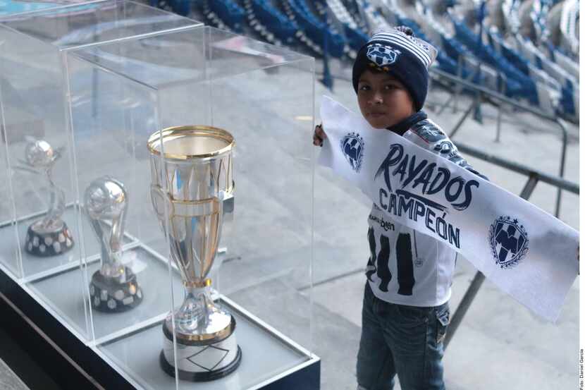 Un pequeño aficionado de Rayados de Monterrey se toma una fotografía con los trofeos que su...
