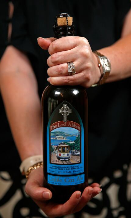 Shannon Birkes holds a bottle of The Lost Abbey's Cable Car Ale, which she has been aging in...
