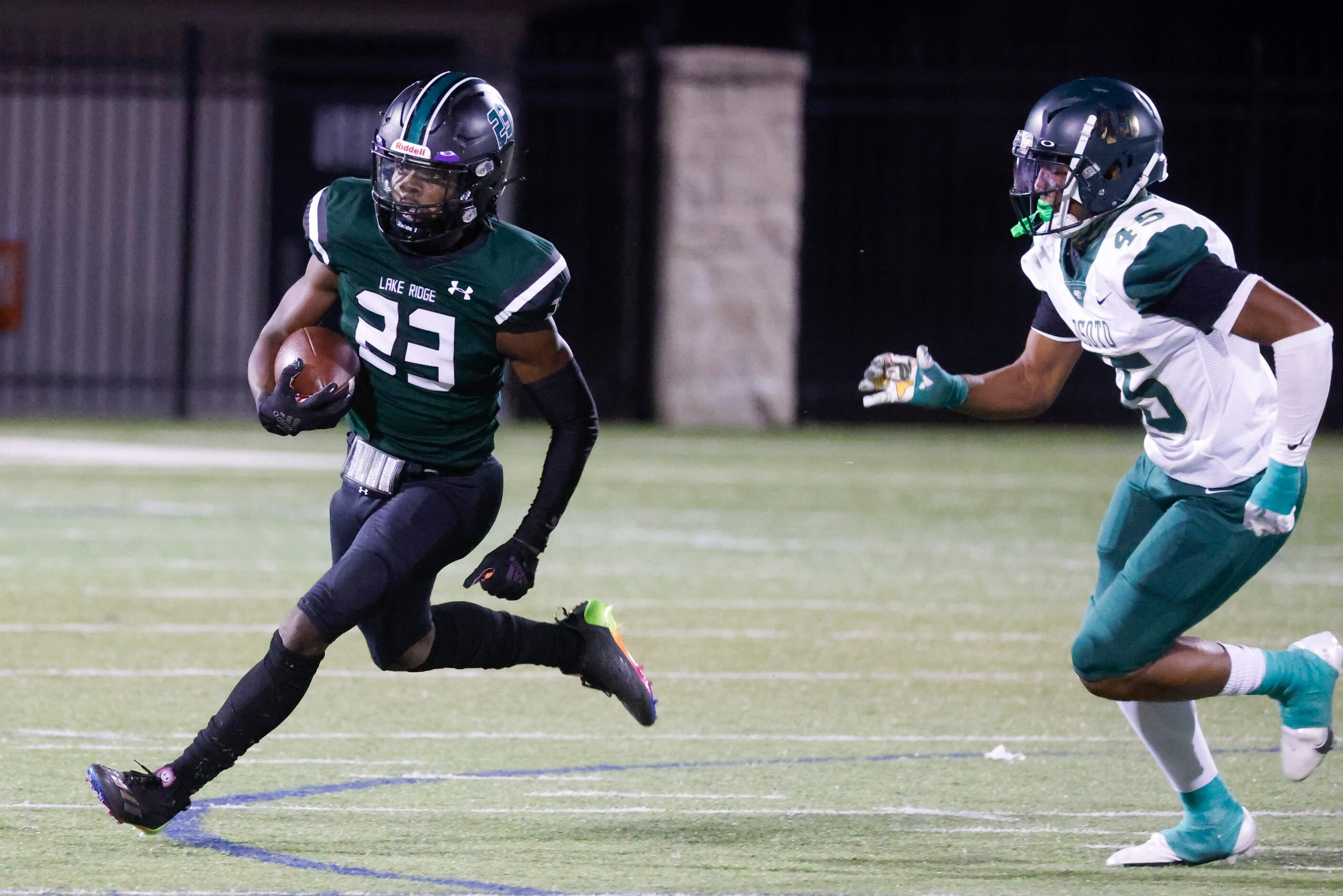 Lake Ridge High School’s Raycine Guilory (23) runs past DeSoto High’s Keylan Abrams (45),...