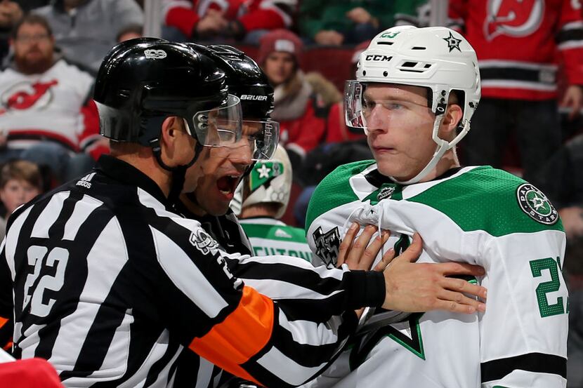 NEWARK, NEW JERSEY - DECEMBER 15:   Esa Lindell of the Dallas Stars is held back by a...