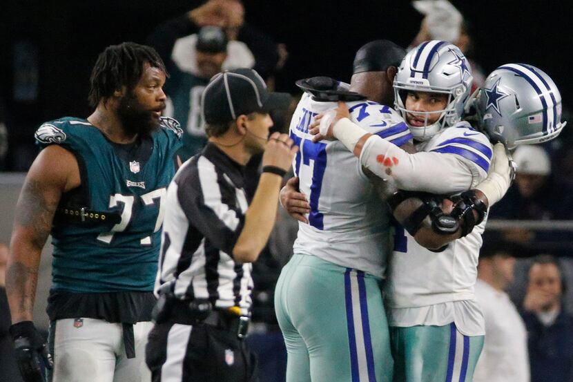Dallas Cowboys quarterback Dak Prescott (4) embraces offensive tackle Tyron Smith (77) after...