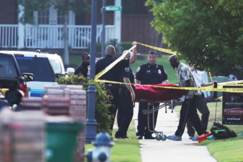 
A body is removed from the scene of the slayings in the 100 block of Sherwood Drive in...