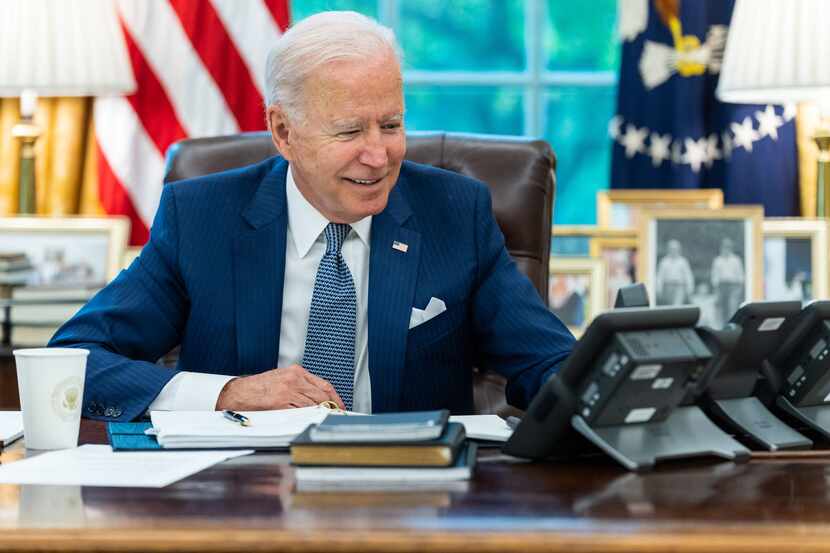 In this image released by the White House, President Joe Biden talks on the phone with...