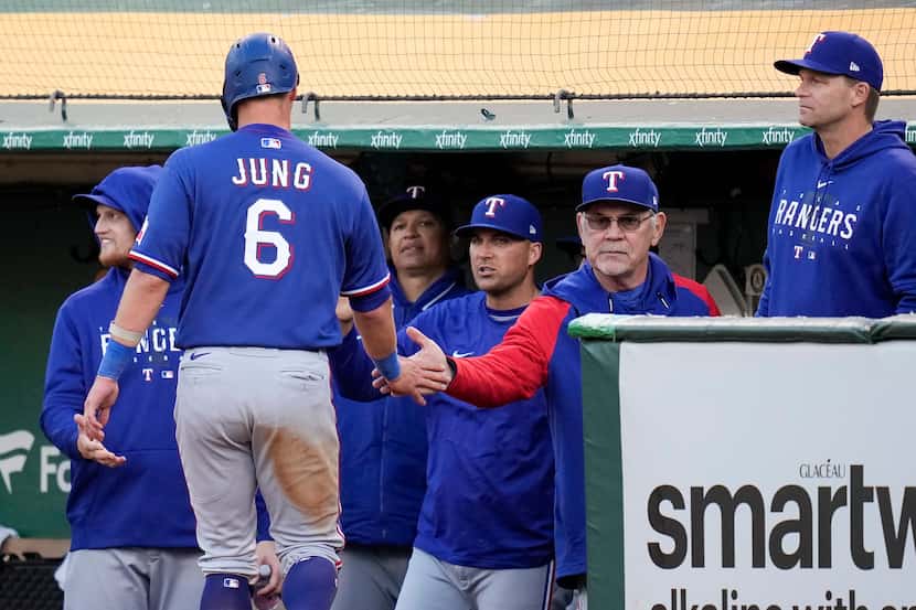 Texas Rangers' Josh Jung, left, celebrates with manager Bruce Bochy after scoring against...