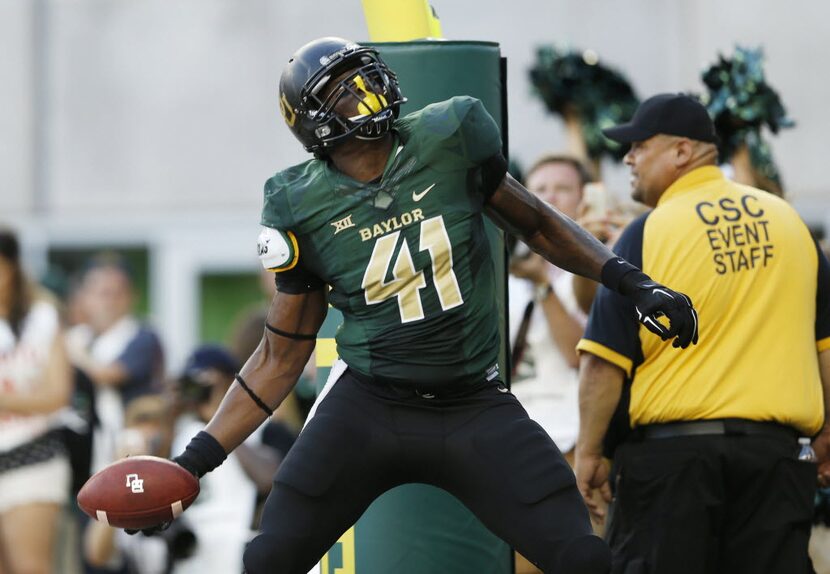 Former Baylor Bears tight end Tre'Von Armstead (41) tosses the ball to the stands after...