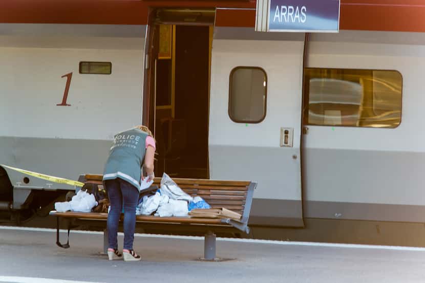 A police officer works on a platform near a Thalys train of French national railway...