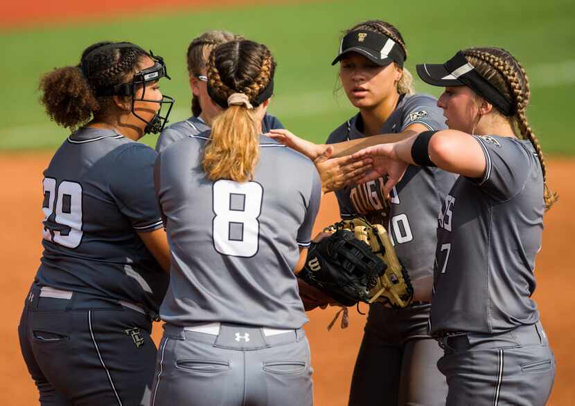 The Colony softball players rally at the mound during the third inning of a UIL Class 5A...