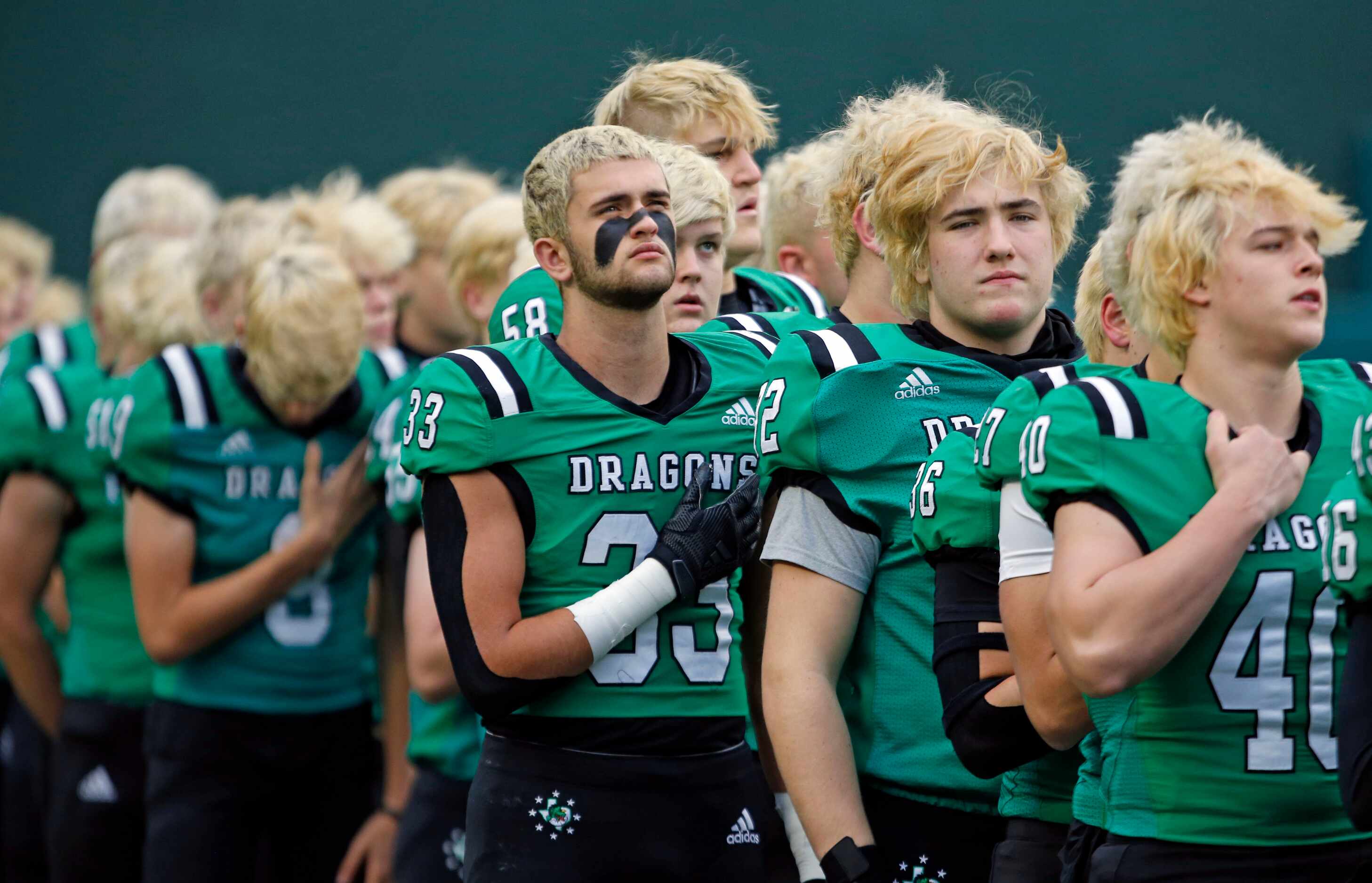 The Southlake football team, all with hair bleached blond for the playoffs, stand for the...