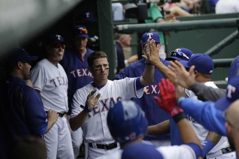 Texas Rangers second baseman Josh Wilson (12) celebrates after scoring during their game...