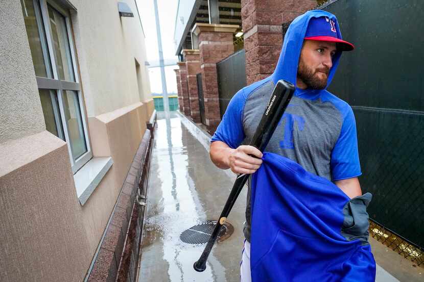 Texas Rangers catcher Nick Ciuffo puts on a warmup as he heads to the indoor batting cage...